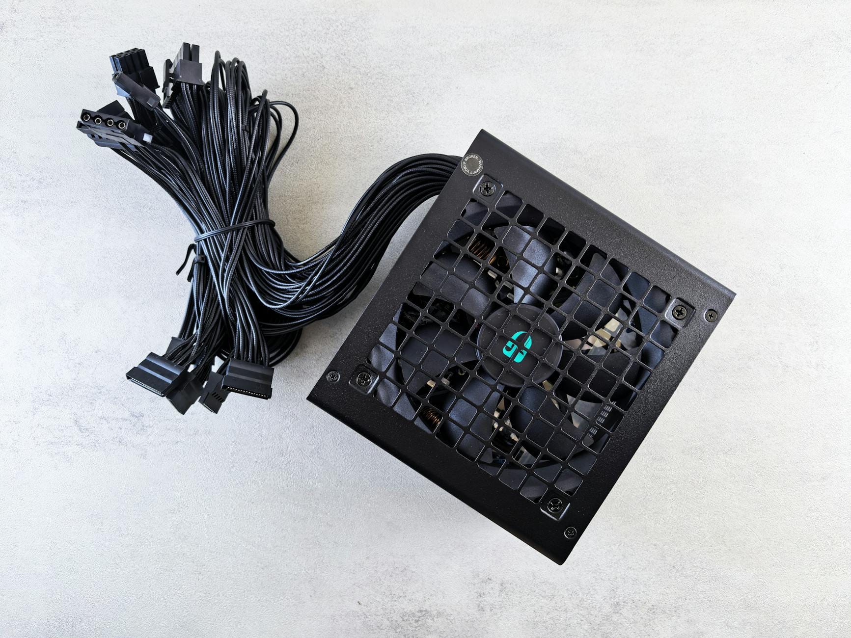 Czarna wysokiej jakości zasilacz komputerowy z przewodami na białym tle