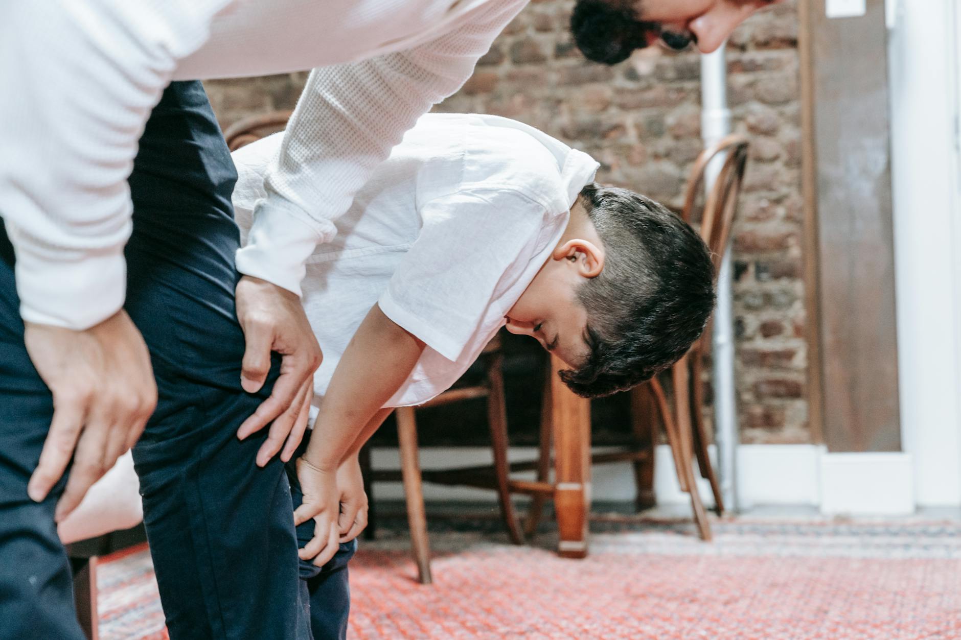 Ojciec i syn modlą się razem w domu, budując bliską więź