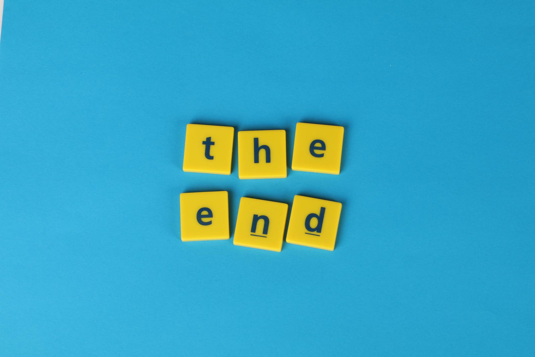 Żółte kostki z napisem the end na intensywnie niebieskim tle