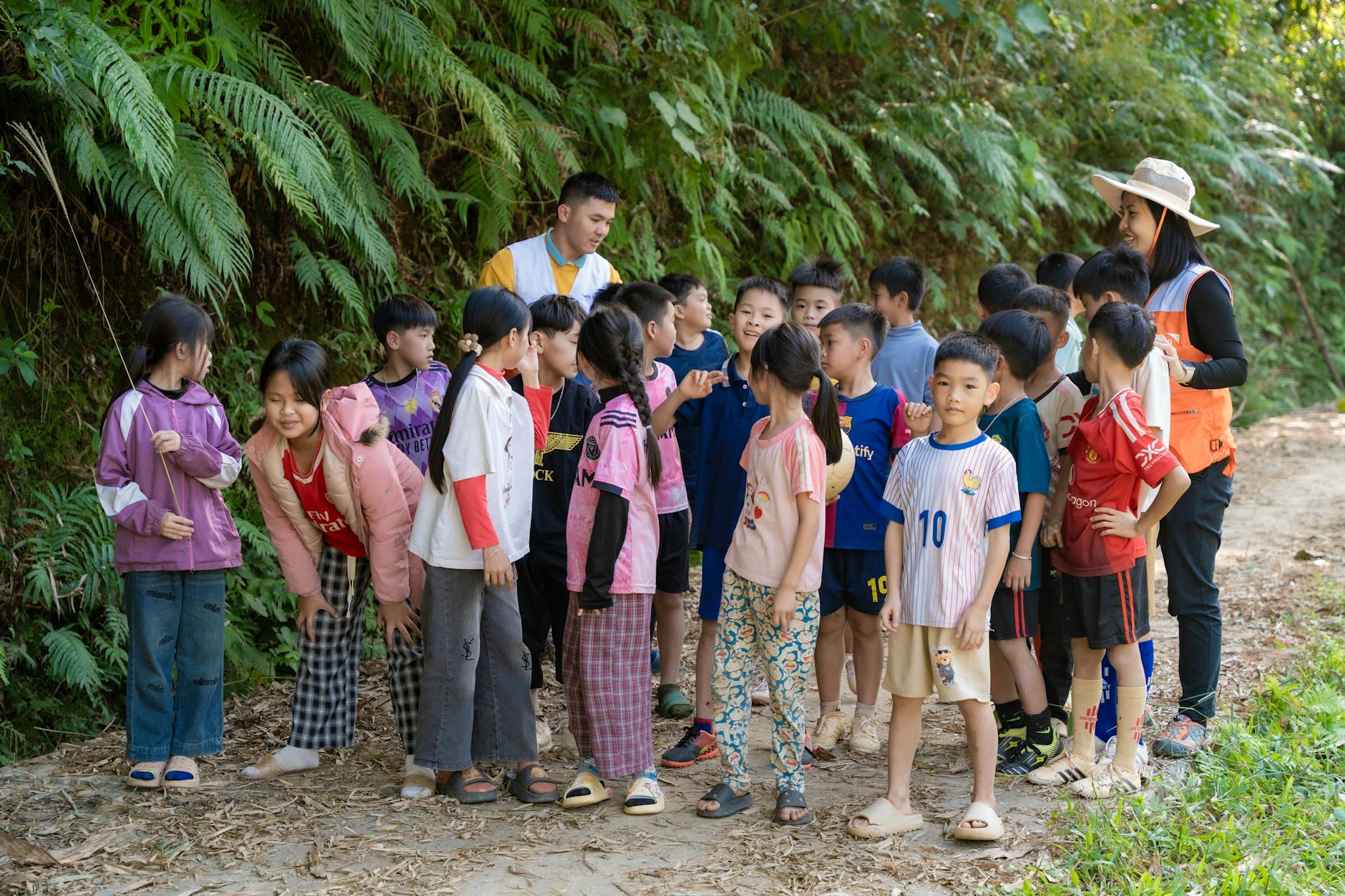 Dzieci na leśnej ścieżce podczas zajęć edukacyjnych z przewodnikami