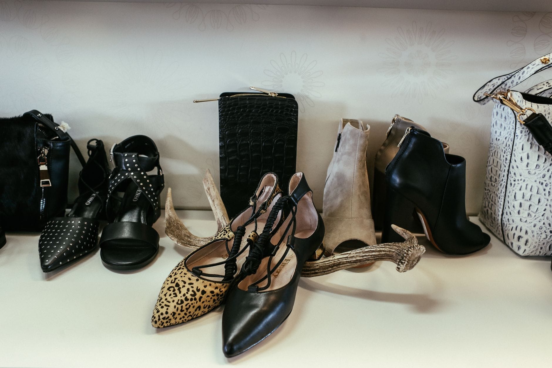 Eleganckie buty i torebki damskie ustawione na półkach w butiku
