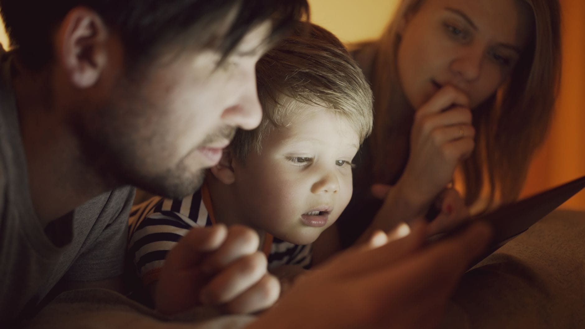 Rodzina z dzieckiem wspólnie ogląda tablet w domu